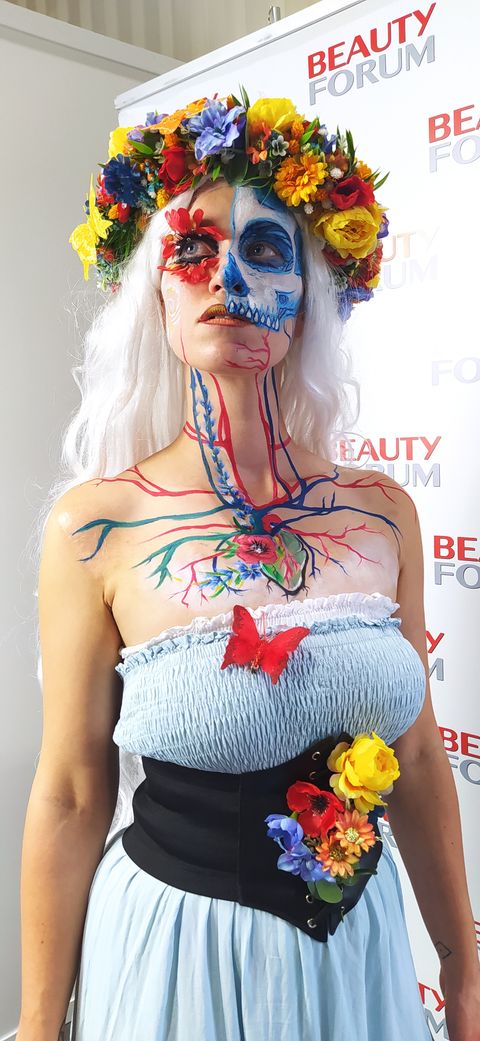 `La Catrina` bodypainting – a woman with skull face paint and circulatory system artwork on her chest, wearing a floral crown. - full resolution