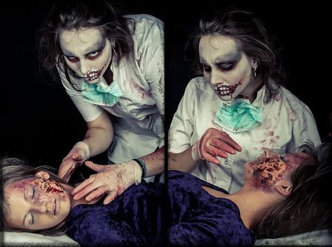 Person in zombie makeup wearing a bloodied medical coat and mask, standing over someone with facial wounds – Halloween horror concept. - full resolution