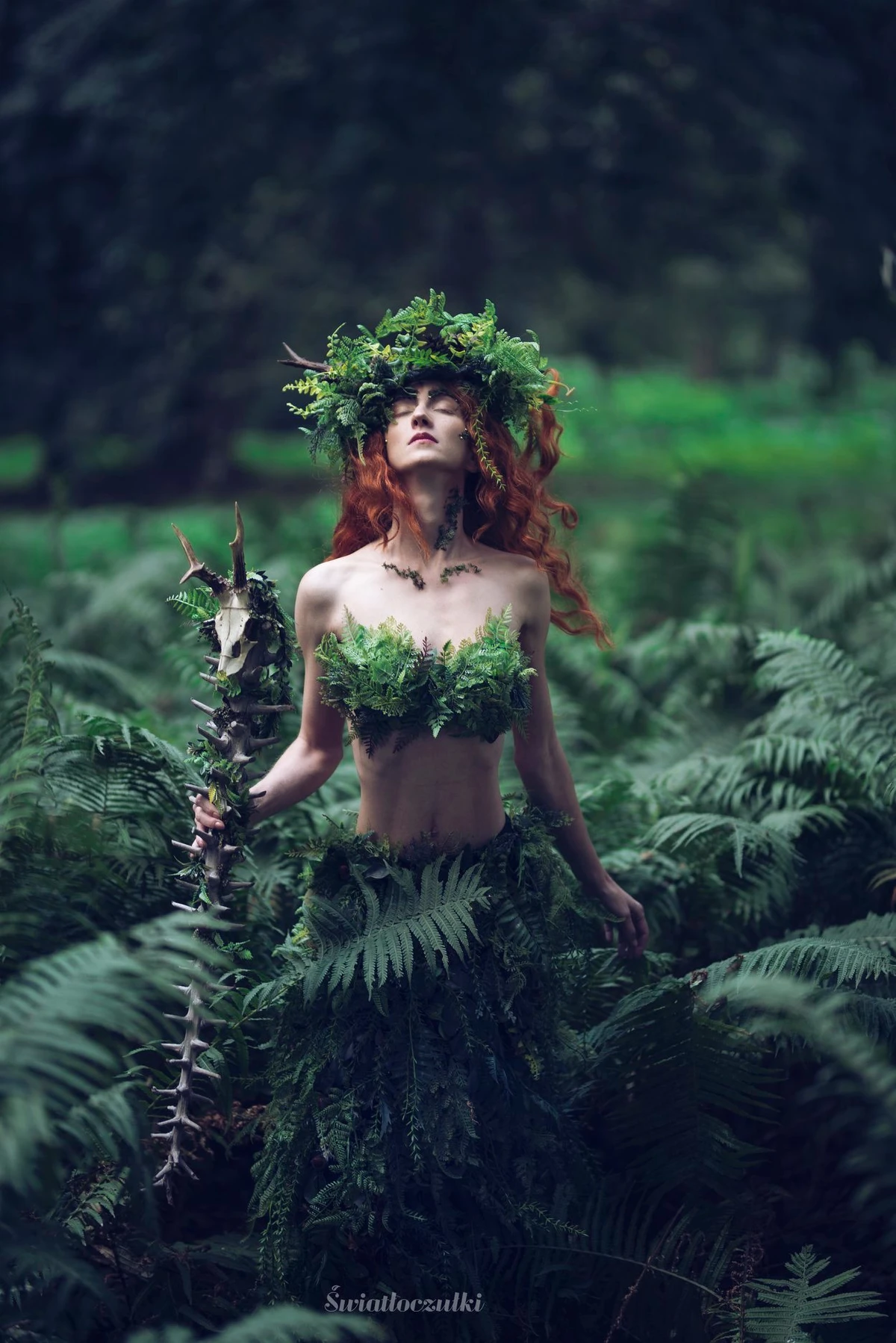 Modelka w roślinnej stylizacji fantasy z zielonym makijażem, wiankiem i liśćmi.