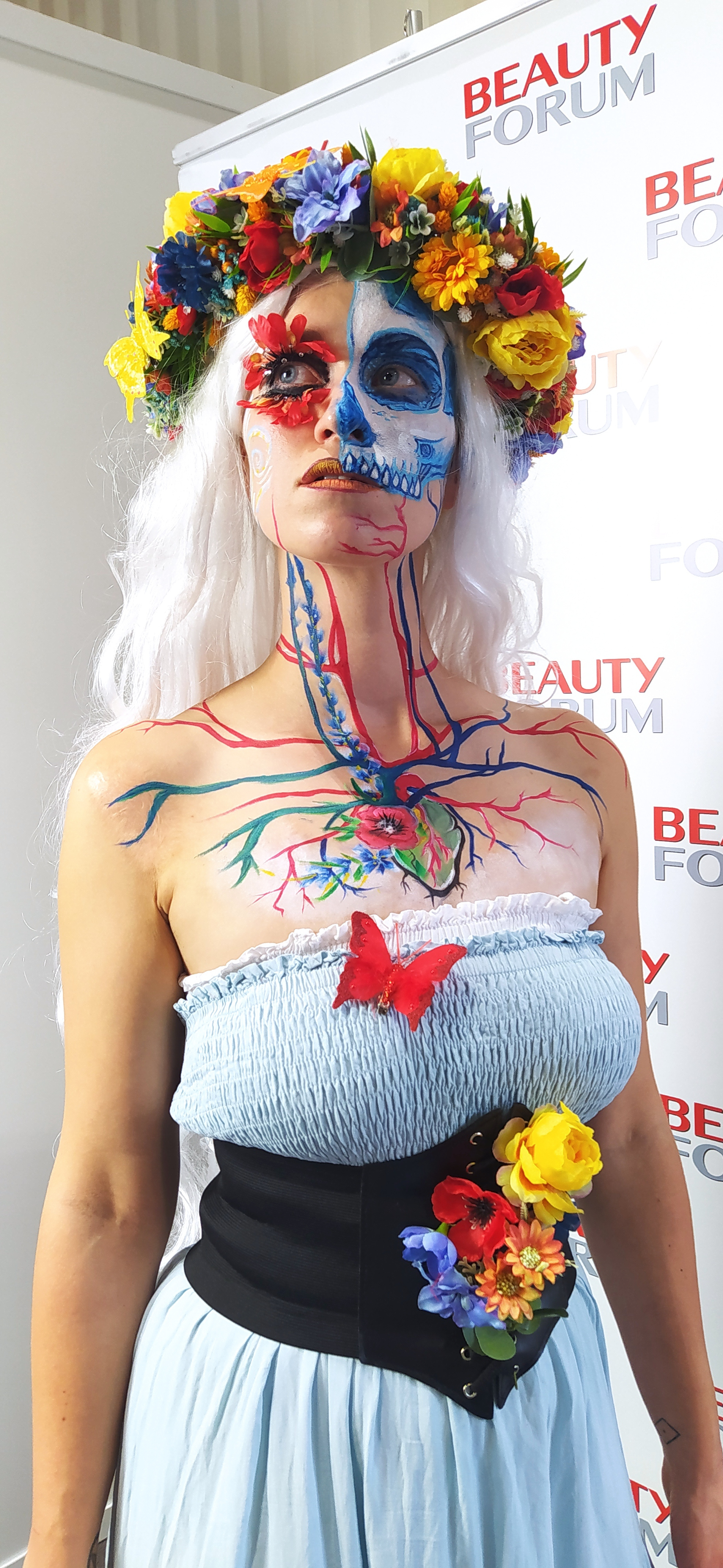 Bodypainting w stylu La Catrina – kobieta z malowaną twarzą czaszki i układem krwionośnym na klatce piersiowej, z kwiatową koroną na głowie. - bezpieczne, hipoalergiczne farby do twarzy i ciała, zmywalne - pełna rozdzielczość  