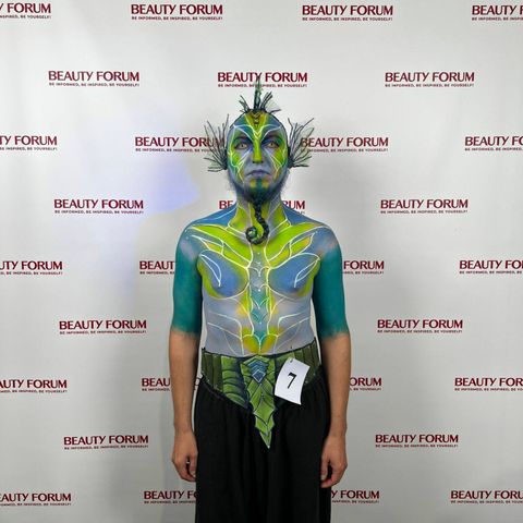 Model z numerem 7 w zielono-niebieskim body paintingu Leśnego Strażnika, widok od przodu podczas Beauty Forum.