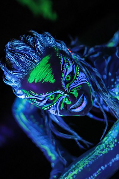 Osoba z fluorescencyjnym malowaniem ciała w stylu tribal, świecącym w świetle UV. - bezpieczne, hipoalergiczne farby do twarzy i ciała, zmywalne - Legnica, Opole, Oława, Lubin, Wrocław, Brzeg - zoptymalizowana wersja do szybkiego ładowania