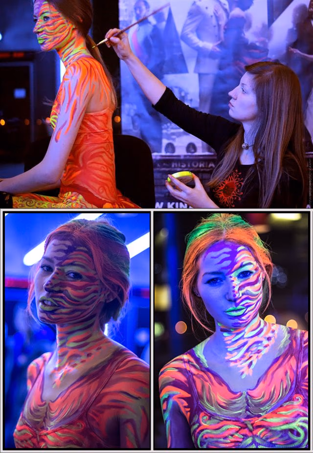 Modelka z fluorescencyjnym body paintingiem przedstawiającym feniksa i płomienie.